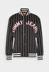 Must rebitud bomberjakk mustade triipudega, millel on punane "TOMMY JEANS" tekst. Omab soonikute ääri ja kraed, käib suurepäraselt kinni nööpidega ning küljetaskutega, millel on valged aktsendid.