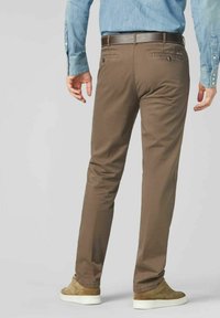 Bruine katoenen broeken met een slim fit, met twee achterzakken en een bruine riem. Gerd gedragen met beige sneakers, wat zorgt voor een casual uitstraling.