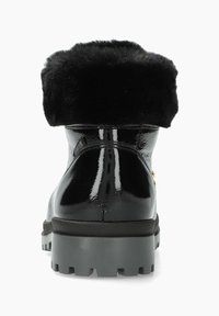 Bottines noires en vernis avec col en fausse fourrure, semelle épaisse grise et accents en métal doré. Texture lisse avec finition brillante.