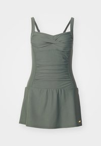 Robe de bain vert foncé avec bretelles réglables, corsage froncé et jupe évasée. Fabriquée en matériau extensible. Logo doré en accent au bas.