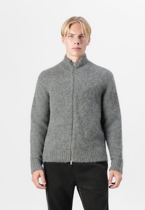 Gray zip-up sweater made of soft wool, featuring a high collar, ribbed cuffs, and hem. The fabric has a fuzzy texture and relaxed fit.