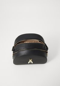 Borsa a tracolla in pelle nera con due scomparti con zip, forma arrotondata, superficie testurizzata e accento in oro a forma di ape sulla parte anteriore.