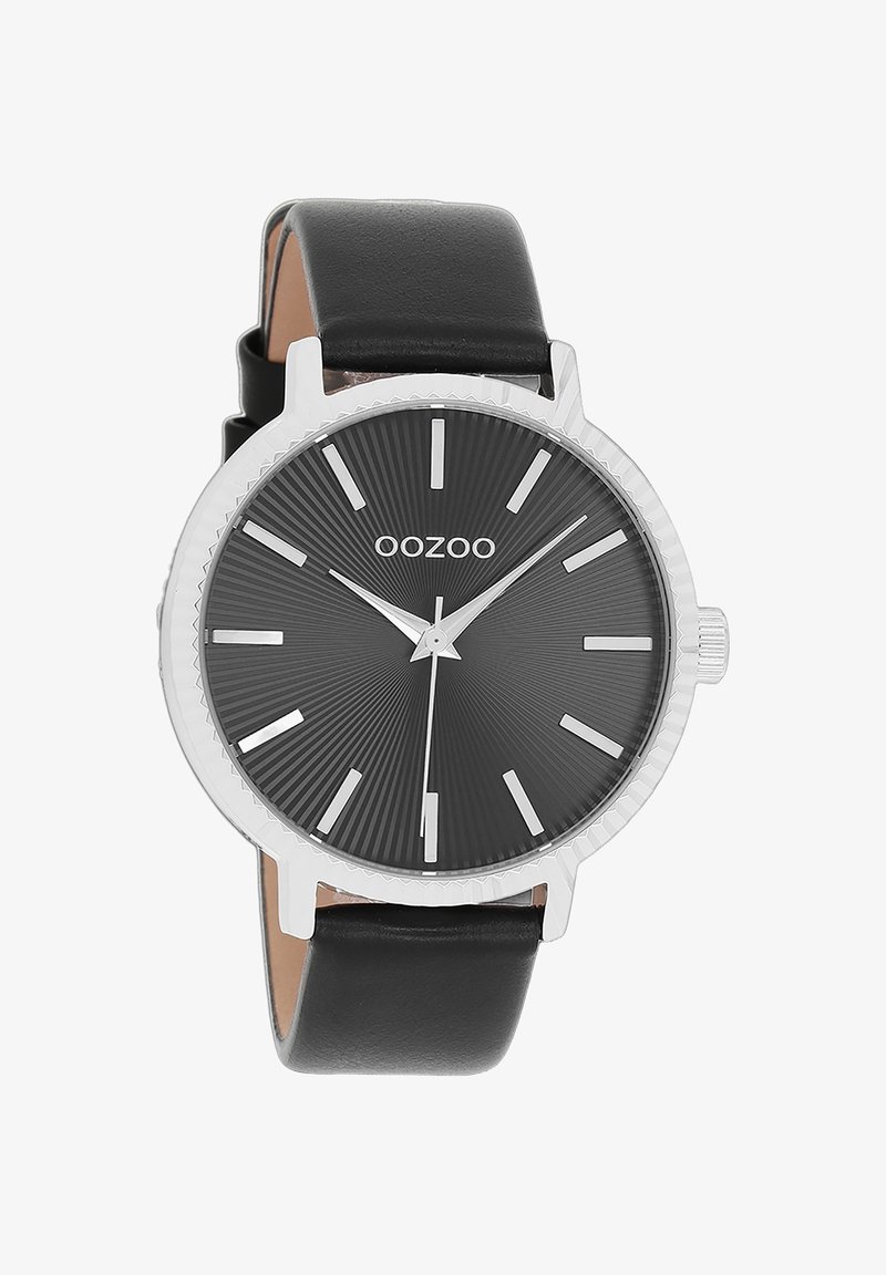 Montre avec bracelet en cuir noir, boîtier en métal argenté, cadran noir texturé, marqueurs horaires argentés et aiguille centrale fine.