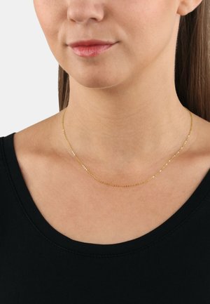 Collar de cadena de oro con eslabones delicados, ajustado a la cuello. Lleva puesto una persona con un escote redondo, diseño minimalista.