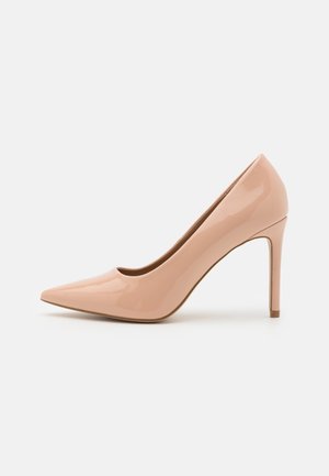 Beige laklæder pump med spids tå og tynd hæl, vist på hvid baggrund.