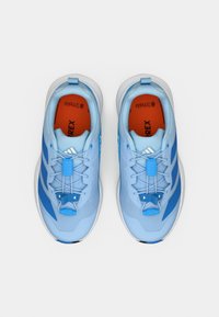 Αθλητικά παπούτσια σε ανοιχτό γαλάζιο με μπλε λεπτομέρειες, επάνω μέρος από δίχτυ και υφή. Διαθέτουν ασφαλές σύστημα κορδονιών και αντίθετη πορτοκαλί εσωτερική σόλα.