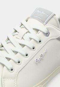 Sneaker bianco con una finitura liscia e testurizzata, dotata di lacci bianchi, una linguetta grigia e un logo "Pepe Jeans" ben visibile sul lato.