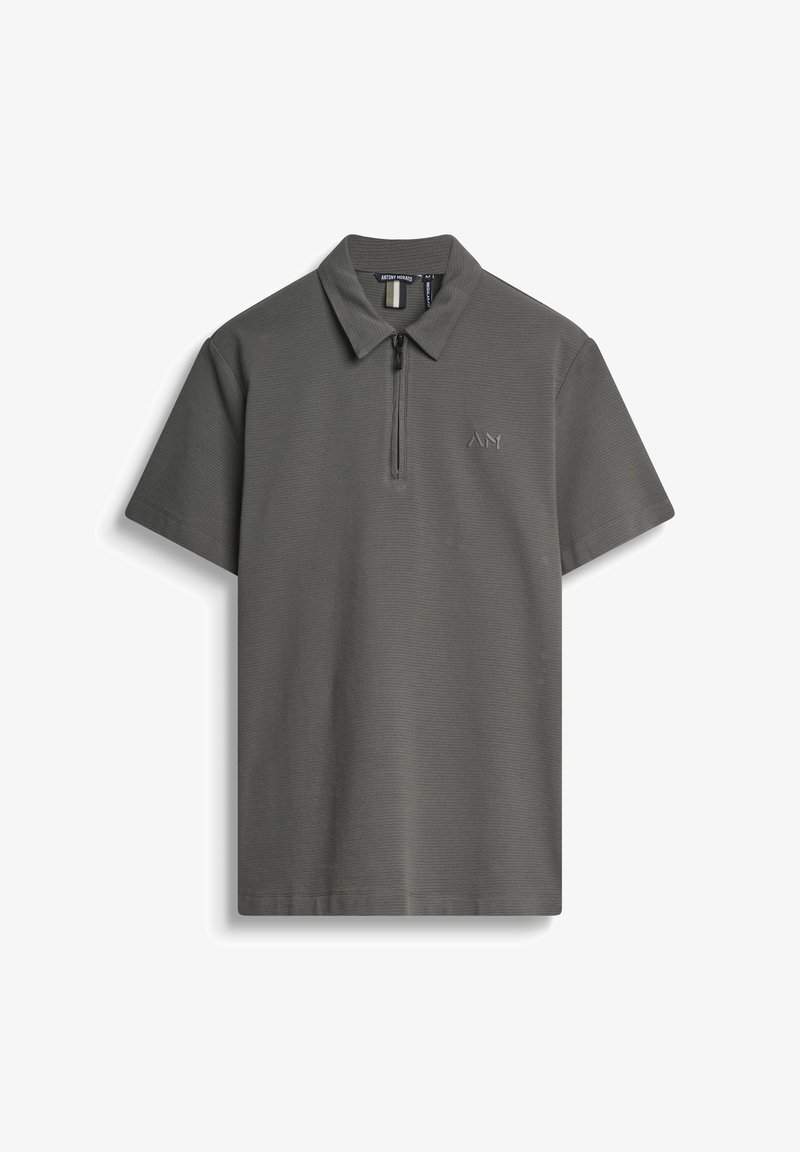 Polo de color gris oscuro con cremallera de cuarto, textura acanalada y un sutil logotipo bordado en el lado izquierdo del pecho. Mangas cortas, cuello clásico.