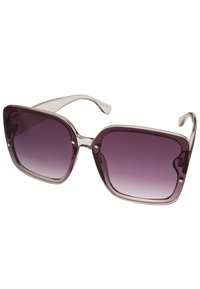 Přehnané sluneční brýle s průhledným fialovým rámem a gradientními tmavě fialovými skly. Mají zaoblený čtvercový tvar a kovové akcenty po stranách.