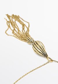 Collier doré avec un pendentif bulbous présentant des rainures verticales et des chaînes en forme de frange, fabriqué en métal avec une finition texturée.