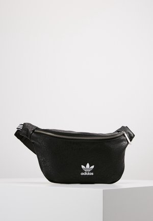 Schwarze, strukturierte Adidas-Gürteltasche mit silbernem Reißverschluss und weißem Adidas-Trefoil-Logo vorne, auf weißem Hintergrund dargestellt.