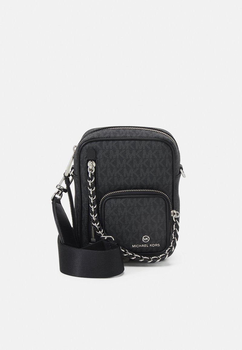 Borsa a tracolla nera con un motivo geometrico, hardware argentato, un accento a catena e una tracolla regolabile. Presenta una tasca con zip sul davanti.
