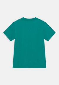 Tyrkysové tričko s krátkým rukávem a kulatým výstřihem. Vyrobeno z měkké bavlněné látky, má jednoduchý design bez vzorů nebo grafik.
