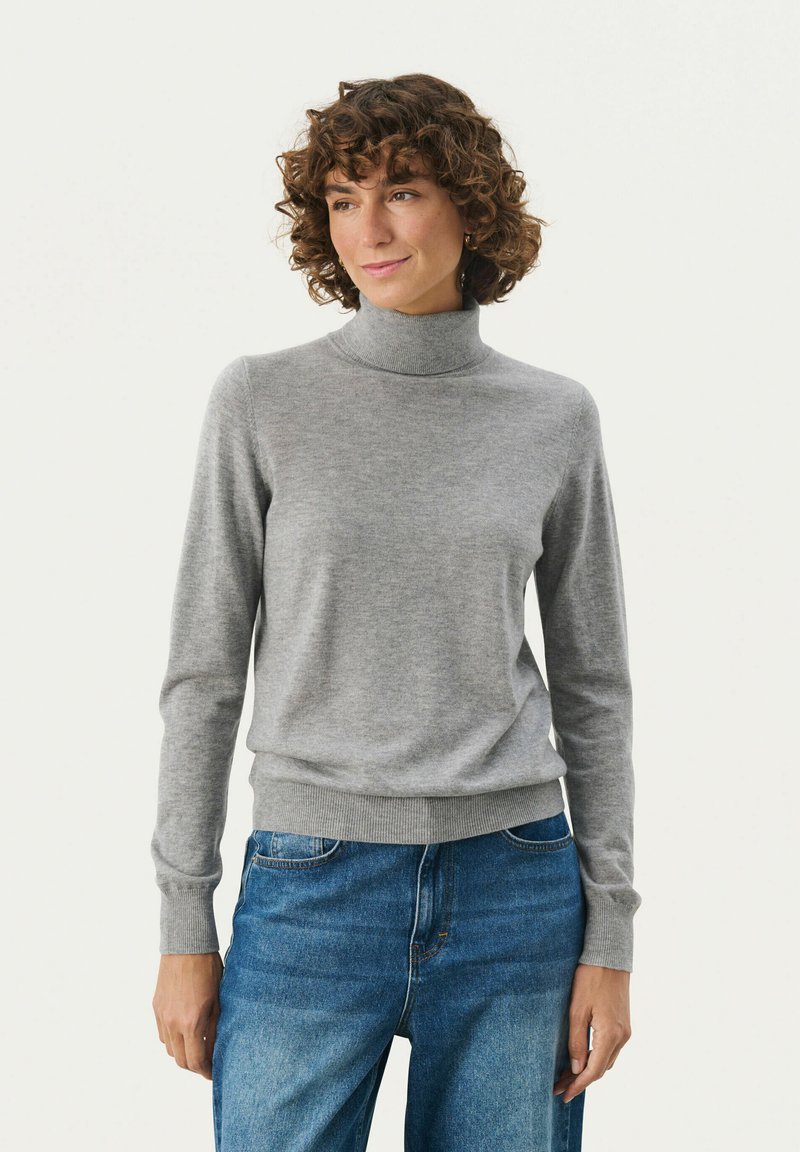 Grå turtleneck sweater lavet af blødt stof, med lange ærmer og ribbet manchetter og kant. Bæres sammen med blå denim jeans.