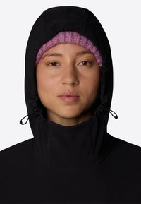 Svart hoodie med hög krage och justerbar dragsko. Har en texturerad, rosa stickad mössa som kikar fram under.