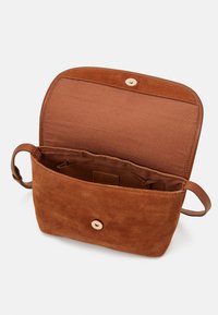 Brown suede bag with a soft texture, featuring a single press-stud closure and a spacious interior. Interior lining is a darker brown.