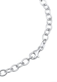 Collier en métal argenté avec des maillons ovales et un fermoir en forme de homard arrondi. La surface est polie, réfléchissant la lumière avec une texture lisse.