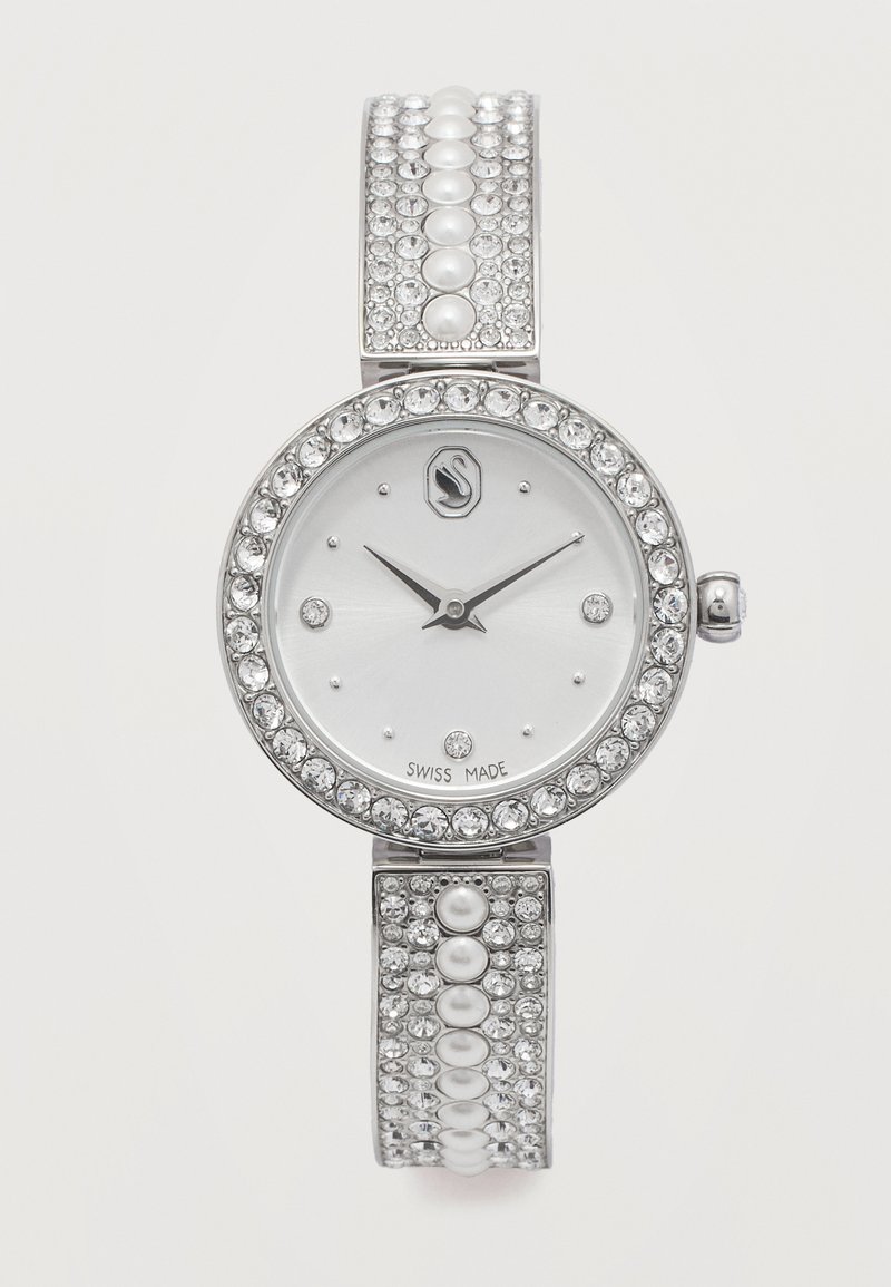 Στρογγυλό ασημένιο ρολόι με στεφάνη κ αι καντράν από κρύσταλλο, λουρί στολισμένο με μαργαριτάρια και κρύσταλλους, ελβετικής κατασκευής, μαύρα λεπτά και ωροδείκτες στη θέση 10:09.