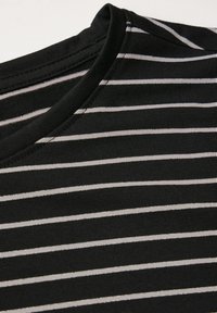 Schwarz-grau gestreifter Stoff mit rundem Ausschnitt und sichtbaren Nähten. Weiche Textur mit glatter Oberfläche, die horizontale Streifen aufweist.