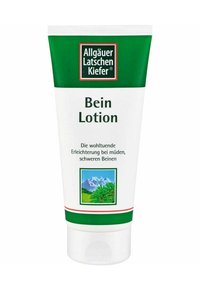 Weißer Tubus mit grünen Akzenten, beschriftet mit "Bein Lotion." Enthält eine Illustration von Bergen und Grünflächen. Der Text auf Deutsch beschreibt die Anwendung.