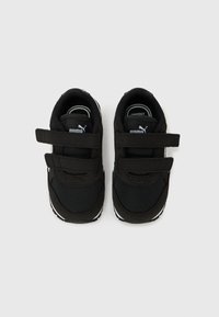 Μαύρα πάνινα παπούτσια για νήπια με δύο λουράκια Velcro, λευκό λογότυπο Puma στη γλώσσα και λευκές λεπτομέρειες στη σόλα, απεικονίζονται από πάνω σε λευκό φόντο.