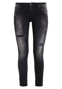 Jean skinny en denim noir avec des détails usés, comprenant des déchirures aux genoux et un léger délavage. Comprend des passants de ceinture standards et une fermeture par bouton.