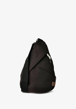 Sac besace triangulaire noir avec bandoulière large réglable et petite écusson logo beige dans le coin inférieur.