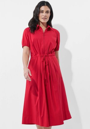 Rotes Kurzarmkleid mit Kragen, Frontreißverschluss und Kordelzug in der Taille. Der Rock hat Falten und reicht bis unter das Knie. Glatte Textur.