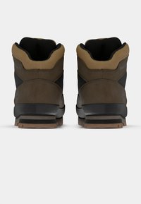 Pruunid ja mustad matkajalanõud tekstuuriga pinnaga, padded krae, tugevad tallad ja kummine haardumine pidamiseks.