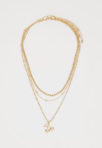 Collier en or avec plusieurs styles de chaînes, ornée d'un pendentif cerise au niveau le plus bas. Finitions texturées et polies.