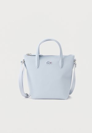 Light blue small handbag with two top handles, a detachable shoulder strap, and a small crocodile logo on the front center.