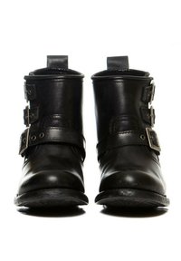 Botas de cuero negro a los tobillos con dos hebillas ajustables, punta redondeada y suela texturizada. Acabado suave con un tacón bajo.