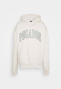 Felpa con cappuccio color crema con tasca frontale, coulisse sul cappuccio e la scritta "PEGADOR" stampata in lettere verdi in grassetto sul petto.