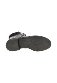 Zwarte leren enkelboot met een getextureerde rubberen zool, voorzien van een zijrits en een gevoerde kraag. De zool heeft een sterpatroon.