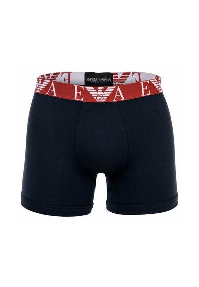 Donkerblauwe boxershorts met een brede rode tailleband met een witte logoprint. Gemaakt van rekbaar, glad materiaal met een aansluitend ontwerp.