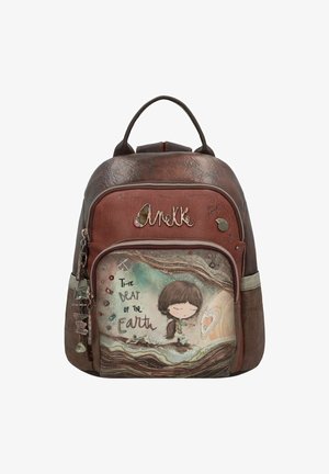 Brauner Leder-Rucksack mit strukturierten Akzenten, ausgestattet mit einer frontalen Tasche, die eine Illustration und den Text "Der Schlag der Erde" enthält, sowie dekorativen Anhängern.
