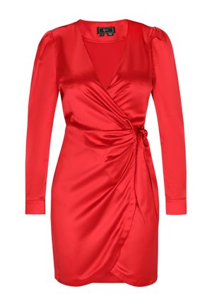 Punainen satiininen kietaisumekko, jossa on pitkät hihat, syvä V-pääntie ja sivuknotti. Suorapintainen rakenne ja vartalon mukaansatempaava istuvuus, jossa on levenevä helma.