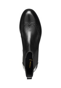 Bota de tobillo de cuero negro con detalles de brogue, puntera redonda, paneles laterales elásticos y una pestaña para facilitar el uso. Marca Geox en la plantilla.