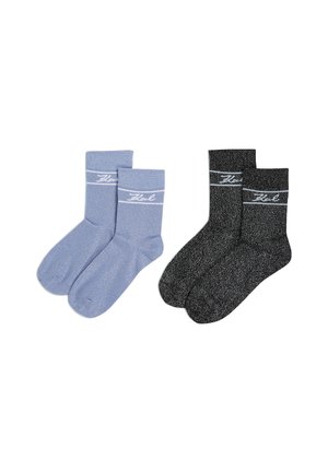 Zwei Paare von Knöchelsocken: ein hellblaues Paar mit glatter Textur und weißem Branding, das andere schwarze Paar mit funkelndem Finish und ähnlichem Branding.