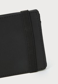 Svart kortholder laget av teksturert materiale, med et horisontalt elastisk bånd. Kantene er sydd for holdbarhet og en jevn overflate.