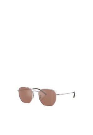 Occhiali da sole con montatura in metallo argentato, forma ottagonale e lenti di colore marrone. Presentano aste sottili e dettagli discreti sulle tempie.