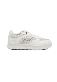 White sneaker with subtle patterned accents, textured canvas and synthetic materials, featuring a raised sole and central lacing.
