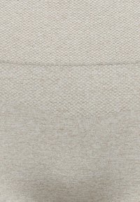 Trois sections horizontales de tissu en maille beige, chacune avec un motif texturé distinct allant du tricot fin au tricot grossier.