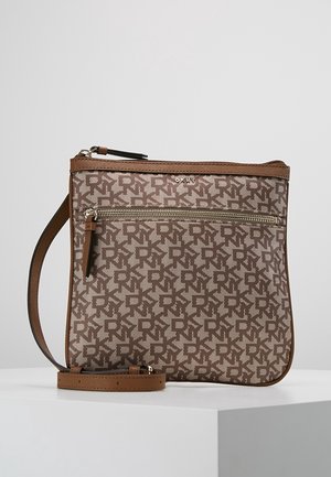 Borsa a tracolla marrone con motivo ripetuto del logo DKNY, tasca frontale con cerniera e tracolla regolabile, posizionata su una superficie bianca con sfondo uniforme.