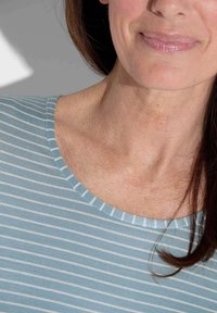 Gestreiftes Oberteil in sanftem Blau und Weiß, runder Ausschnitt, weicher Stoff, mit dünnen Streifen und lässiger Passform, sichtbarer Textur und Nähten.