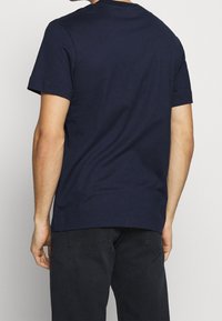 Navy blue cotton t-shirt with short sleeves, crew neck, and a relaxed fit. Minimalist design, no visible patterns or logos.