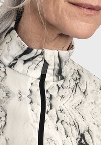 Fitted Jacke mit einem schwarz-weißen Marmor-Muster, hohem Kragen, durchgehendem Reißverschluss und strukturiertem Stoff, mit einem Logo auf der Vorderseite.