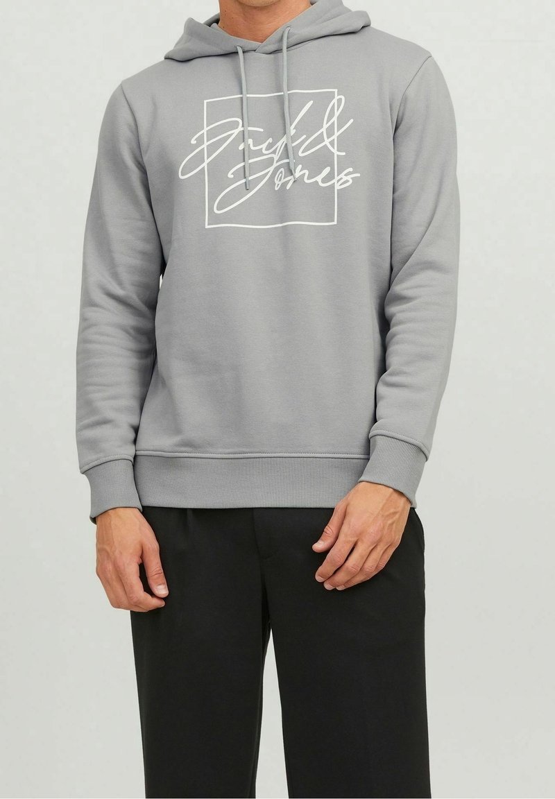 Sudadera con capucha gris hecha de una tela suave, que presenta un diseño gráfico blanco dentro de un cuadrado en la parte delantera, con puños y dobladillo acanalados.