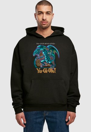 Black hoodie featuring a graphic design of a blue dragon over a golden globe with "Yu-Gi-Oh!" text. Material appears soft, with a front pocket.