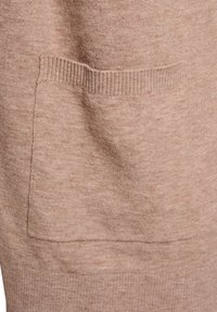 Beežist kootud kangas pehme tekstuuriga, millel esiosas suur plaastritasku ning tasku servades soonikdetailid.